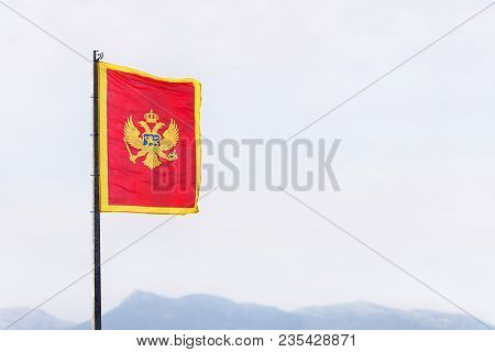 The Flag Of Montenegro (red, With The Two-headed Eagle Coat Of Arms In The Middle, And Golden Border