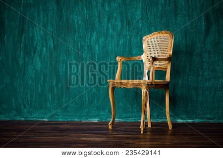 Old Chair On A Green Wall Background