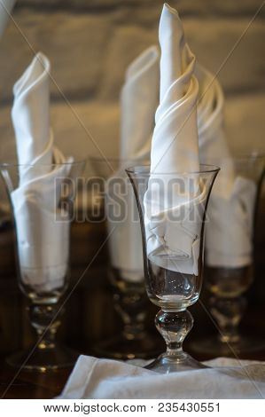 Wine Glasses On A Wooden Table With White Napkings