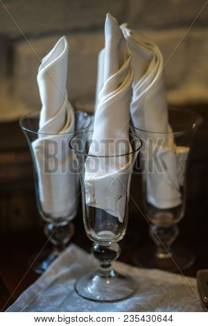 Wine Glasses On A Wooden Table With White Napkings