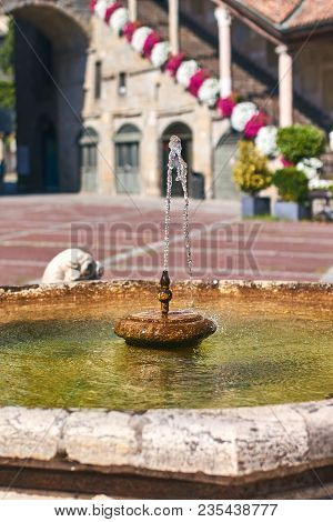 Old Contarini Fountain On Piazza Vecchia Square In Bergamo, Italy With Beautiful Flowers On Backgrou