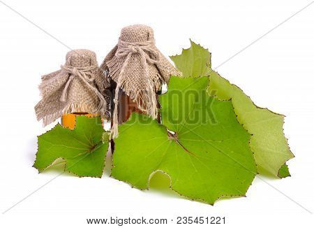 Coltsfoot Leawes With Pharmaceutical Bottle Isolated On White.