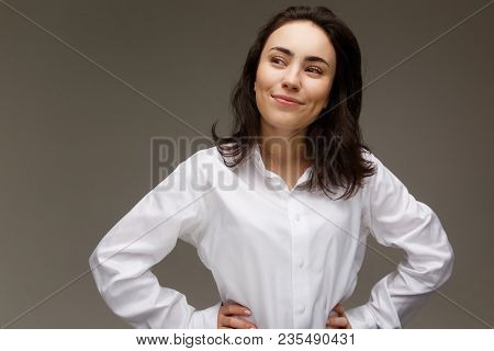 Beautiful Girl In A White Shirt Shows Emotions. On A Light Background.