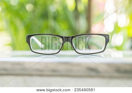 Glasses On Table In The Park With Blurred Tree Background