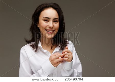 Beautiful Girl In A White Shirt Shows Emotions - Smile, Fun. On A Light Background.