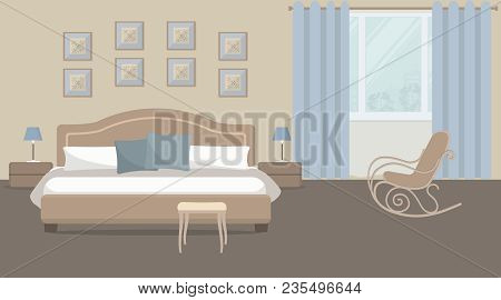 Bedroom In A Beige Color. There Is A Bed With Blue Pillows, Bedside Tables, A Rocking Chair On A Win