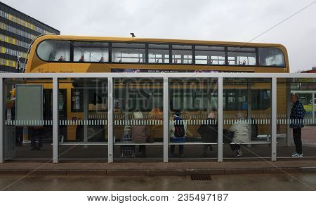 Bracknell, England - April 03, 2018: A Group Of People Waiting In A Bus Station Shelter For Their Bu