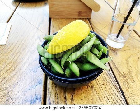 Green Peas With Lemon With A Glass Of Water Stand On A Wooden Table