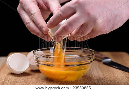 Man Hands Breaking An White Egg Egg Shells At The Cutting Board
