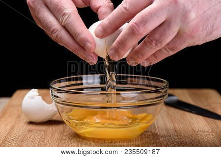 Men's Hands Open An Egg Shell An Empty Egg Shell Lies On A Chopp