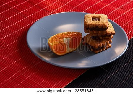 Chocolate Chip Cookies And Piece Of Orange On Plate And On Red And Black Background With Place For T