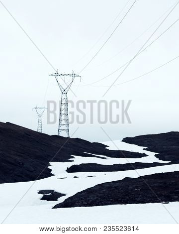 Typical norwegian landscape with snowy mountains and electric line near the famous Aurlandsvegen (Bjorgavegen), mountain road, Aurland, Norway.