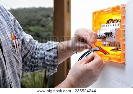 Electrician Technician At Work On A Residential Electric Panel, Prepares The Wire With His Hands