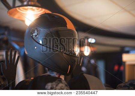 Black Fashion Carbon Motorcycle Helmet With Orange Insets On The Shelf In The Shop