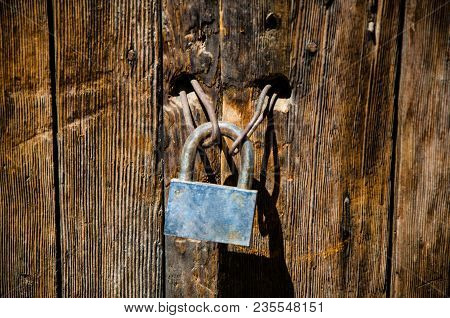 Occident Padlock On An Old Deteriorated Door
