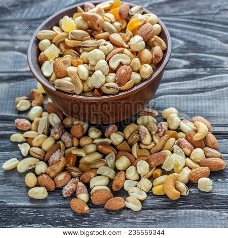 Mix Nuts In Earthenware On A Wooden Background.