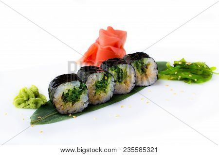 Delicious Fresh Mini-rolls With Algae Of Chukka On A Banana Leaf. Sushi Rolls On A White Background 