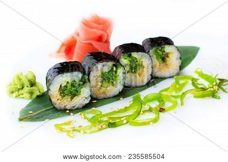 Delicious Fresh Mini-rolls With Algae Of Chukka On A Banana Leaf. Sushi Rolls On A White Background 
