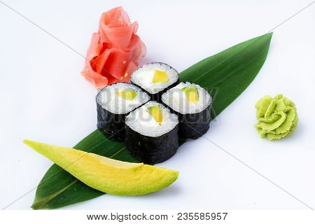 Delicious Fresh Mini-rolls With Avocado And Cheese On A Banana Leaf. Sushi Rolls On A White Backgrou