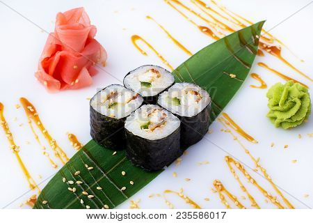 Delicious Fresh Mini-rolls With Cucumber, Eel And Cheese On A Banana Leaf. Sushi Rolls On A White Ba