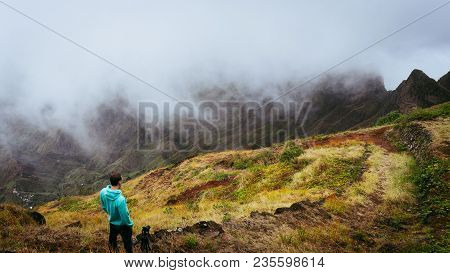 Panoramic Shot Of Traveler Taking Picture Of Amazing Steep Mountain Range And Terrain Canyon Valley 