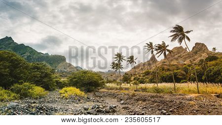 Panorama Of Dried-up Stream Surrounded By Fertile Green Valley And Rugged Cliffs. Santo Antao, Cabo 