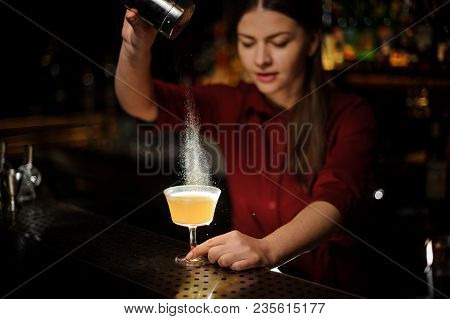 Female Bartender Serving A Fresh Delicious Yellow Cocktail And Pouring A White Spice Into It On The 