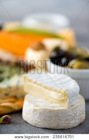 Assortment Of Hard, Semi-soft And Soft Cheeses With Olives, Grissini Bread Sticks, Capers, Grape, On