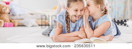 Girl Whispering Joke To Sister