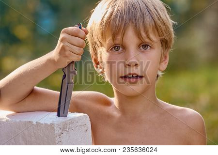 Portrait Of Young Smiling Athletic Boy With Throwing Knife