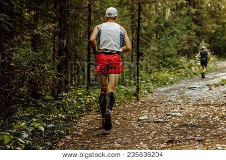 Back Male Runner In Compression Socks And Cap Run Forest Trail