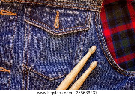 Drum Sticks Lie On A Scottish Cage And Jeans