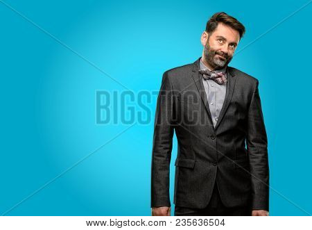 Middle age man, with beard and bow tie with sleepy expression, being overworked and tired