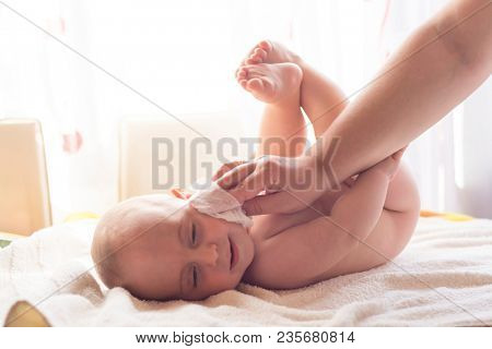 Hygiene - young momy wiping the baby skin with wet wipes. Cleaning wipe, pure, clean