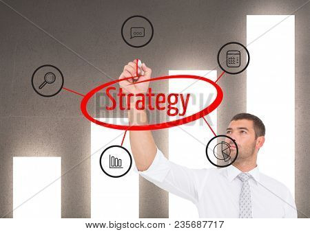 Businessman doing a graphic about STRATEGY in the screen. Graph wall background