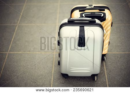 Two Suitcases On Grey Blurred Background. Summer Vacation And Travel Concept. Traveler Suitcase With