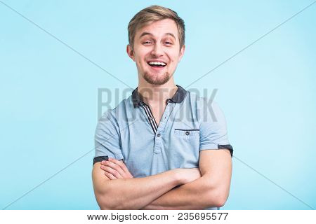 Portrait Of A Handsome Young Man Smiling Against Blue Background