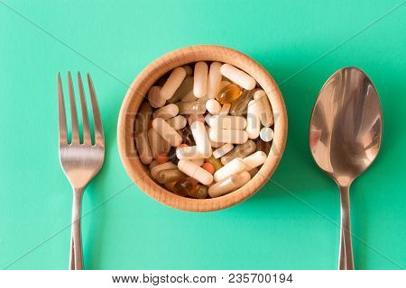Lots Of Multicolored Pills In A Plate On Turquoise Background . Fork And Spoon . The Concept Of A He