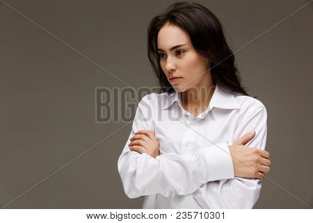 Beautiful Girl In A White Shirt Shows Emotions. On A Light Background.