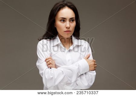 Beautiful Girl In A White Shirt Shows Emotions. On A Light Background.