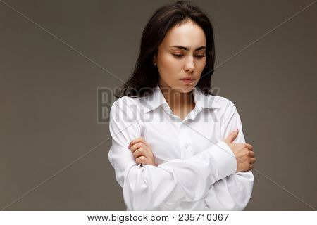 Beautiful Girl In A White Shirt Shows Emotions. On A Light Background.