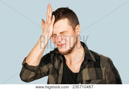 Young Guy With Beard And Modern Hairstyle Mohawk, Oblivious And Holds Hand At The Head Isolated On B