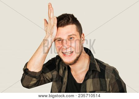 Young Guy With Beard And Modern Hairstyle Mohawk, Oblivious And Holds Hand At The Head Isolated On W