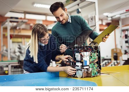 Young Attractive Students Of Mechatronics Working On Project Together