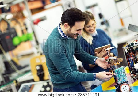 Young Attractive Students Of Mechatronics Working On Project Together
