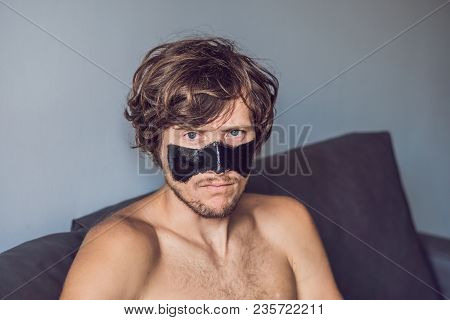 Happy Man With Black Mask On The Face. Photo Man Receiving Spa Treatments. Beauty Skin Care Concept.