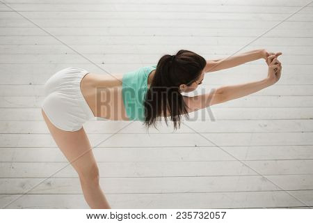 Young Sporty Woman Doing Streching Exercises In Bright Interior. Correct Posture. Perfect Rear. Prot