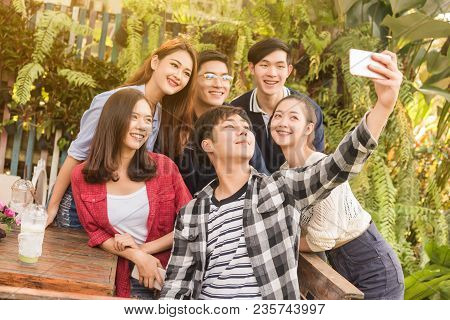 Group Of Six Teenagers Taking Selfie With Fun Together In Afternoon