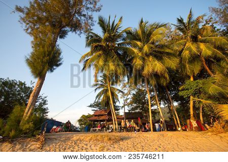 Lumut Perak, Malaysia - March 20, 2018: Family Traveler Sitting Under The Coconut Tree At The Beach.
