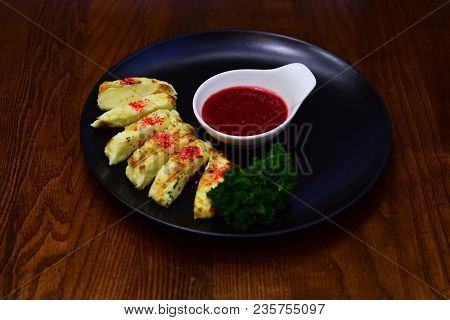 Dish Of Grilled Cheese Served With Raspberry Sauce On Black Plate, Wooden Background. Delicious Chee